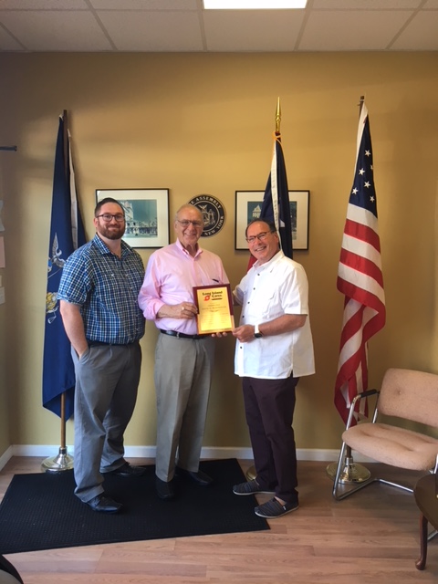 Assemblyman Dave McDonough  (R,C,I-Merrick)[center] is awarded a plaque by Long Island Cares, Inc. CEO Paule T. Pachter [right] and Chief Governmental Affairs Officer Michael W. Haynes [left] for his