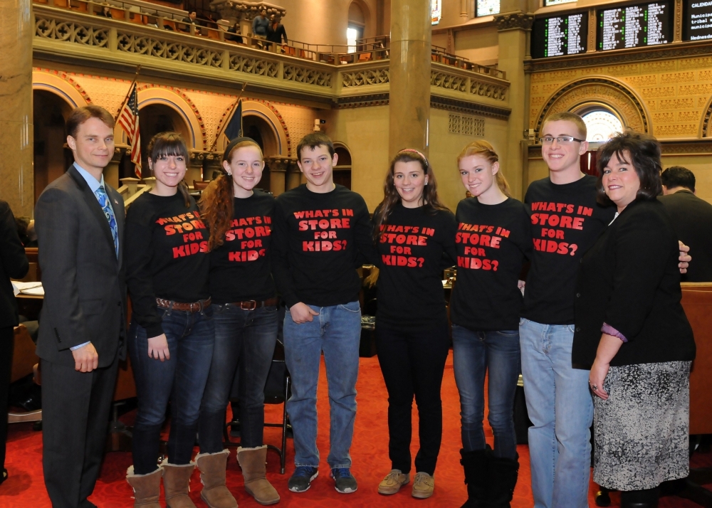 Pictured with Assemblyman Chris Friend (left) are Anna Evanek, Rachael Schweiger, Dakota Skinner, Annie Wainwright, Taylor Ayres, Dustin Sherman and Robin Baker, representatives and students from Real